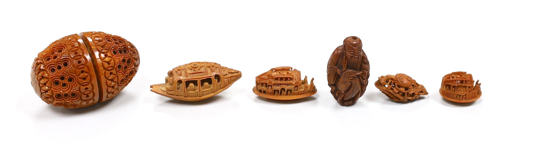 Five Chinese peach stone carvings, largest 4.2cm and a coquilla nut egg shaped box